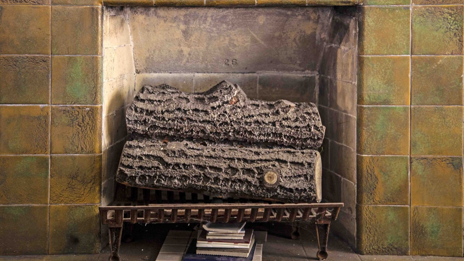little fireplace with logs and tile surround